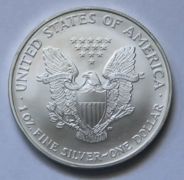 A silver dollar coin with an eagle on it.