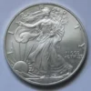 A silver coin with the image of an eagle on it.