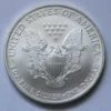 A silver dollar coin with an eagle on it.