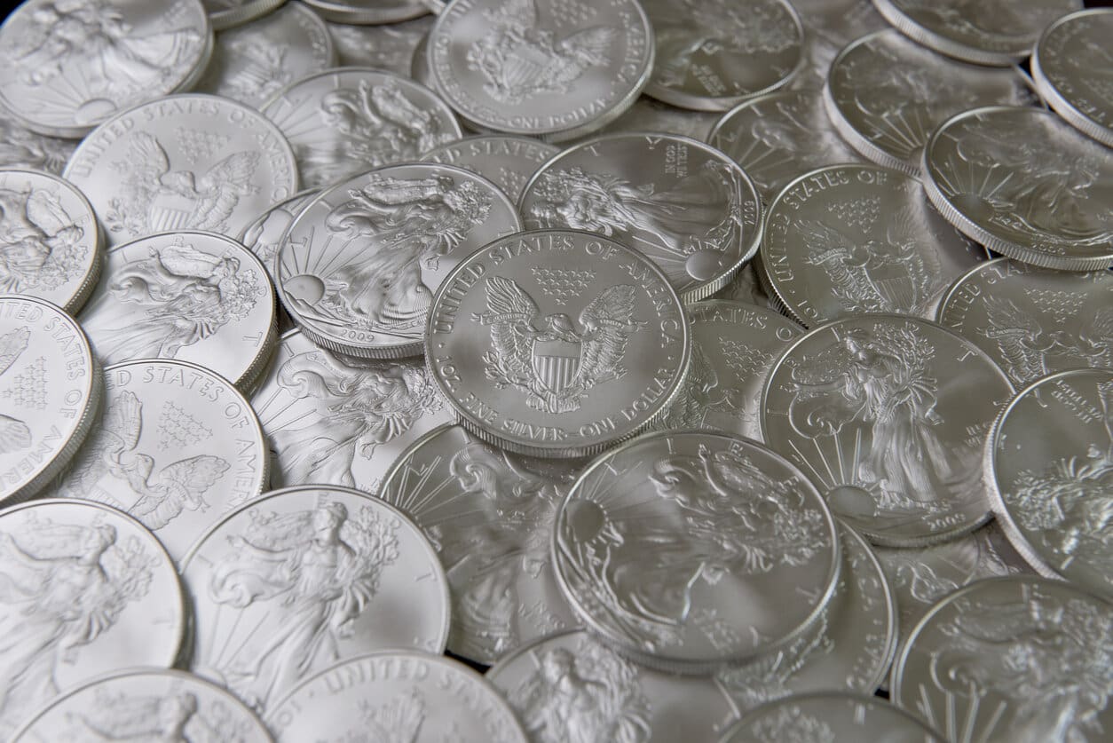 A pile of silver coins sitting on top of each other.